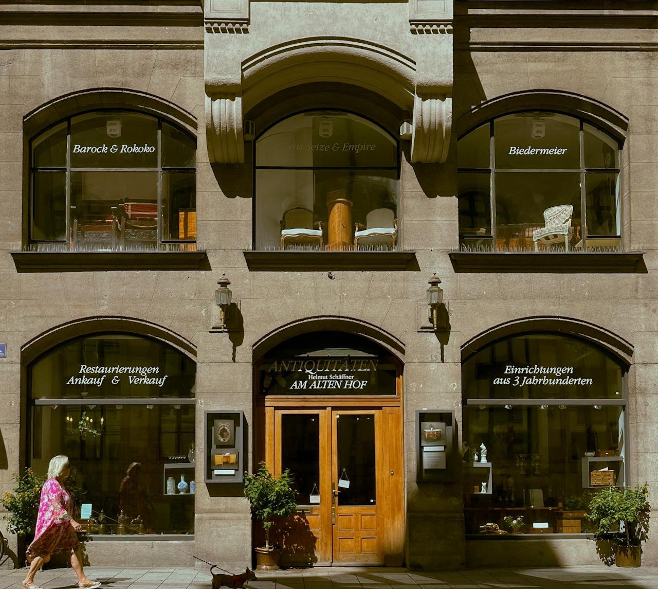 Elegant antique store facade in Munich, showcasing classical furniture and design.