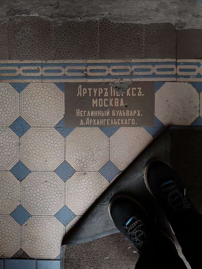 Top view of vintage mosaic tiles featuring Russian text in an old building.