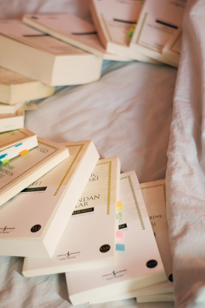 A cozy scene of books with colorful tabs on a bed, suggesting learning or study.